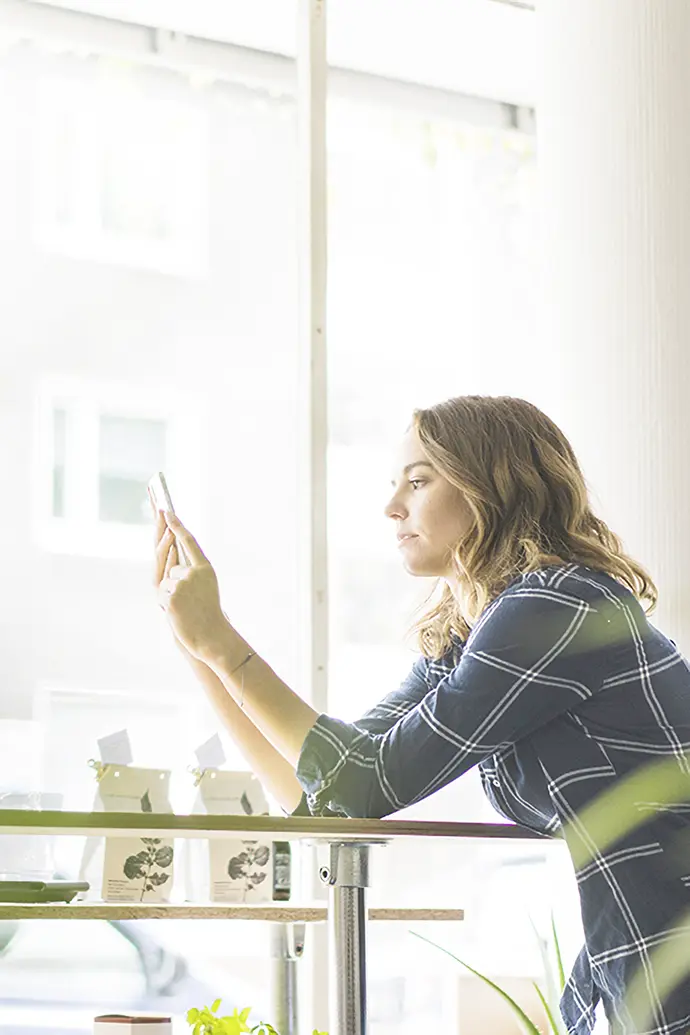 カフェでスマートフォンを見ている女性