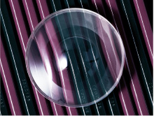 [photo] Clear, circular lens on top of black and purple striped surface