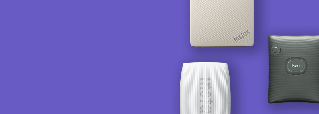 [photo] 3 instax™ smartphone printers in different colors over a purple background