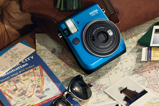 Câmera mini 70 azul ilha no sofá e mapa-múndi