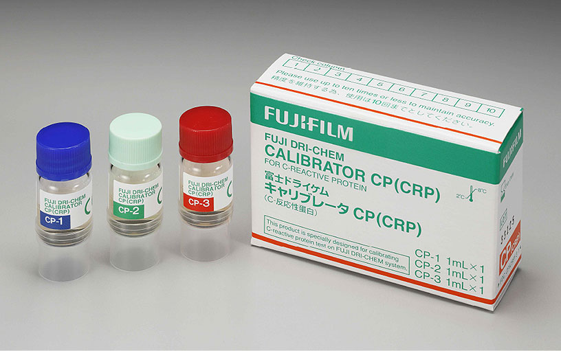 [foto] Três frascos de calibrador CP (CRP) - CP-1 com tampa azul, CP-2 com tampa verde clara e CP-3 com tampa vermelha, ao lado da caixa do calibrador CP (CRP)