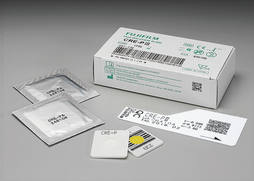 [photo] Box of CRE-P Ⅲ DRI-CHEM Slides with 2 slides in foil wrapper, 2 slides without packaging (front and back view), and QC card