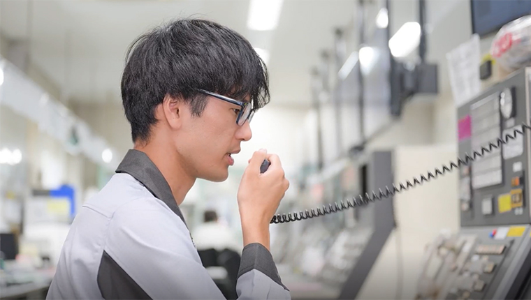 管制室でキビキビと作業指示をする男性社員