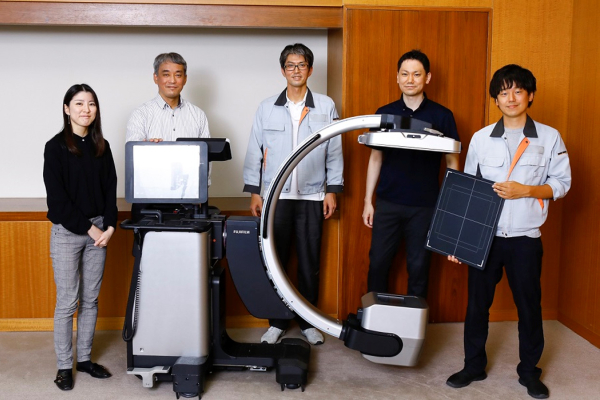 医療機器とともに並ぶ開発チームのメンバー