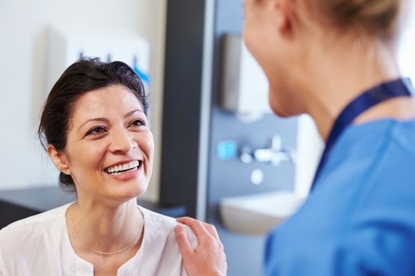 Picture femal patient and nurse smiling at each other