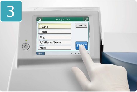 [photo] Gloved hand pressing START button on touchscreen display of DRI-CHEM NX500V