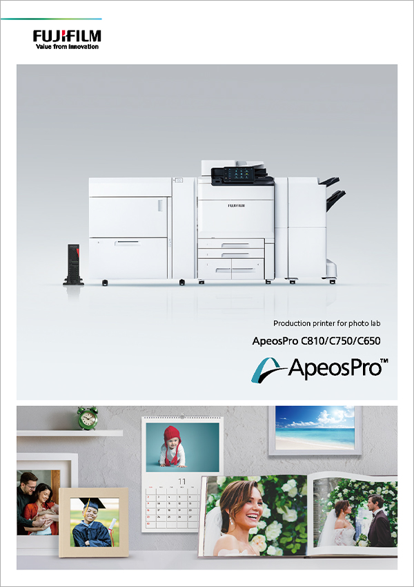 ApeosPro production printer and photo lab products displayed as framed photos, calendar, and photo book on shelf.