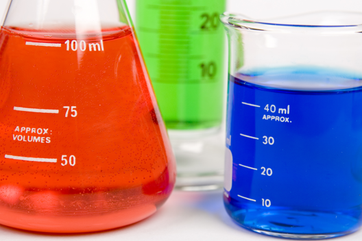 Three beakers filled with Red, Green, and Blue liquids