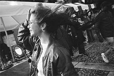 Person on a city street with hair blowing in the wind