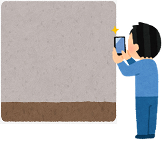 スマホで壁を撮影している人のイメージ