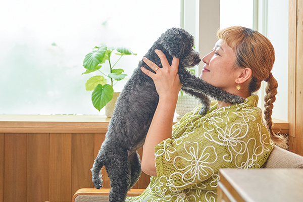 丸山桂里奈氏が愛犬すももちゃんを抱き上げ、微笑んでいる写真