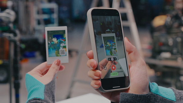 instax mini Evo Cinema™で撮影してプリントしたQRコード付きのチェキプリントでQRコードをスマホで読み込んでいる