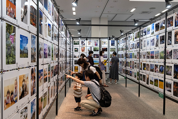 写真展会場にて来場者が作品を楽しむ様子