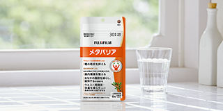光が差し込む窓際に置かれたサプリメントと水の入ったグラスとボトル