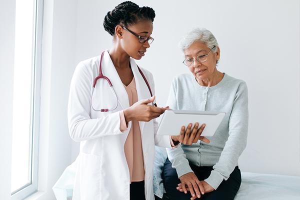 A doctor and a patient talking while looking at a tablet