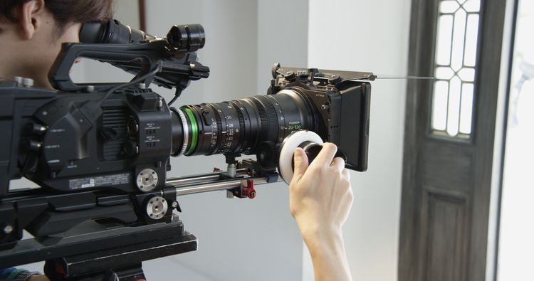 [photo] A cameraman's hand on a follow-focus wheel attached to an XK Lens on a Sony Camera