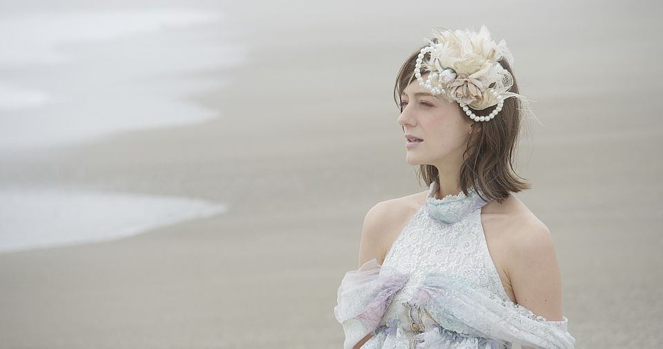 [photo] A lady in a dress standing on the beach