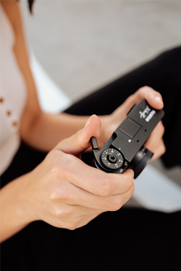 Holding the “X half” in her hand, operate the frame switch lever with your thumb.