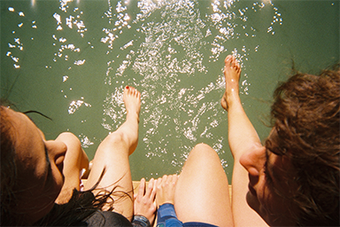 Two people relaxing with their feet in the water