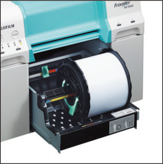 [photo] Paper tray open with paper roll sitting in tray of DE100 printer