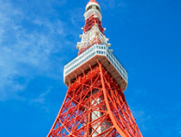 [photo] External view of the red and white Tokyo Tower from ground level up with blue sky background