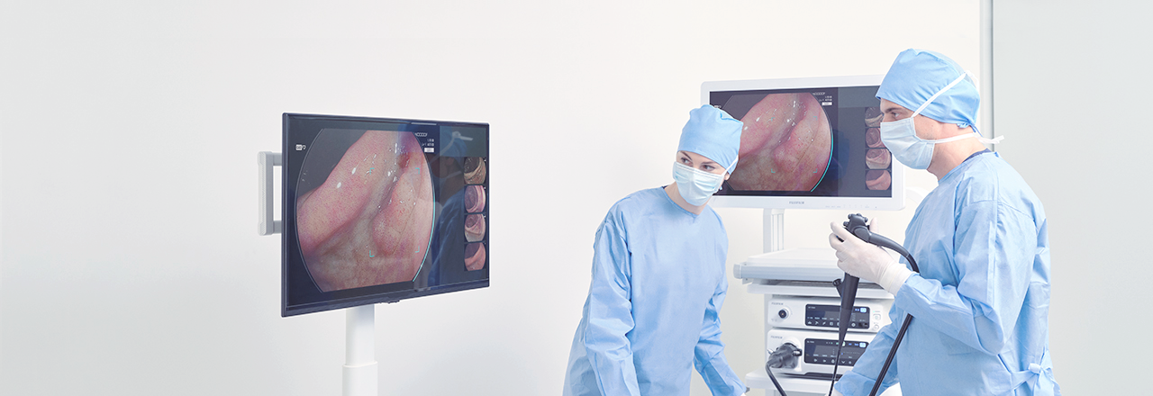 Two doctors working in front of a screen with an endoscope