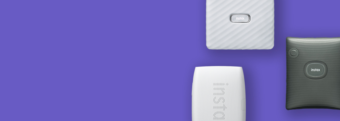[photo] 3 instax™ smartphone printers in different colors over a purple background
