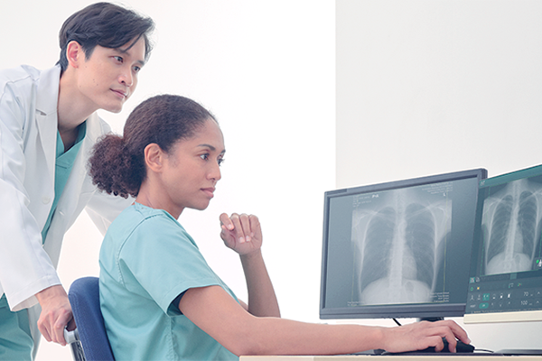 Doctors talking while reviewing results through monitors