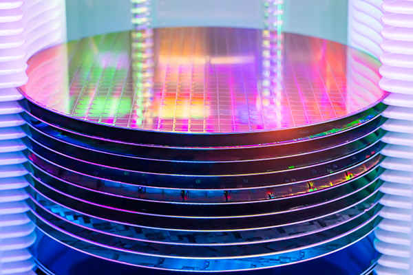 An image of a wafer, a semiconductor material that is illuminated by multiple lights.
