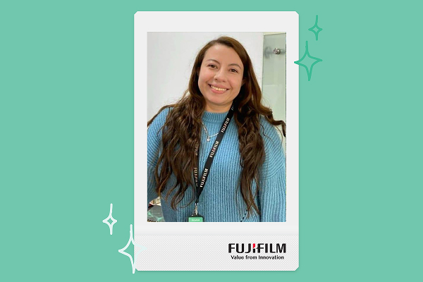 a woman wearing a blue shirt smiles within an instax print frame