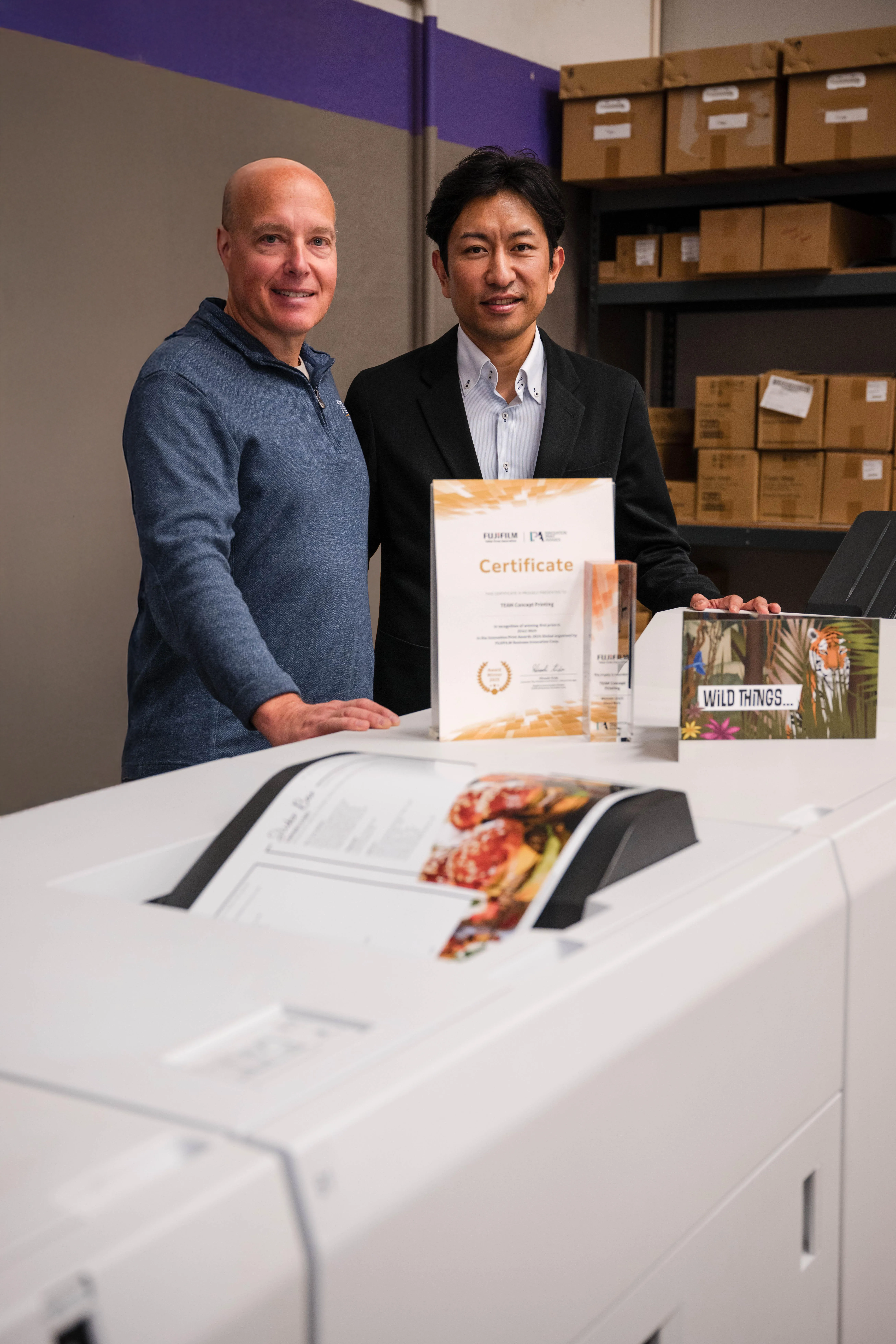 A Fujifilm executive presents an award to a print service provider.