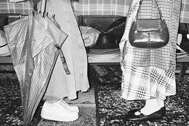 Close-up of a person’s feet and umbrella on a rainy day
