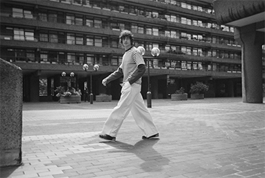 Full-body shot of a person walking on a city street