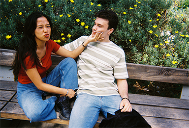 Photo of a man and a woman sitting on a bench taken with “QuickSnap™”